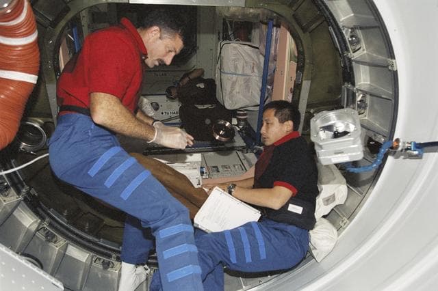 NASA image: MS Burbank and MS Lu work in PMA1 during STS-106