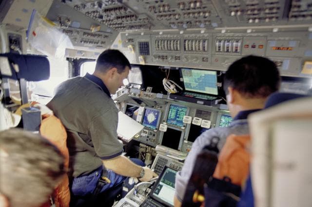 NASA image: Pilot Altman and MS Lu work on the flight deck during docking to ISS