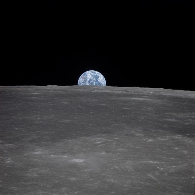NASA image: Apollo 11 Mission image - View of moon limb,with Earth on the horizon,Mare Smythii Region