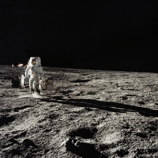 NASA image: Astronaut Alan Bean with subpackages of the ALSEP during EVA
