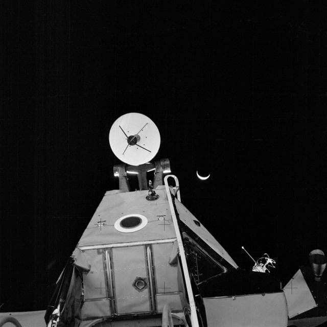 NASA image: Apollo 14 Mission image - Dark view of an Earth crescent and the Lunar Module taken from the surface of the moon. 