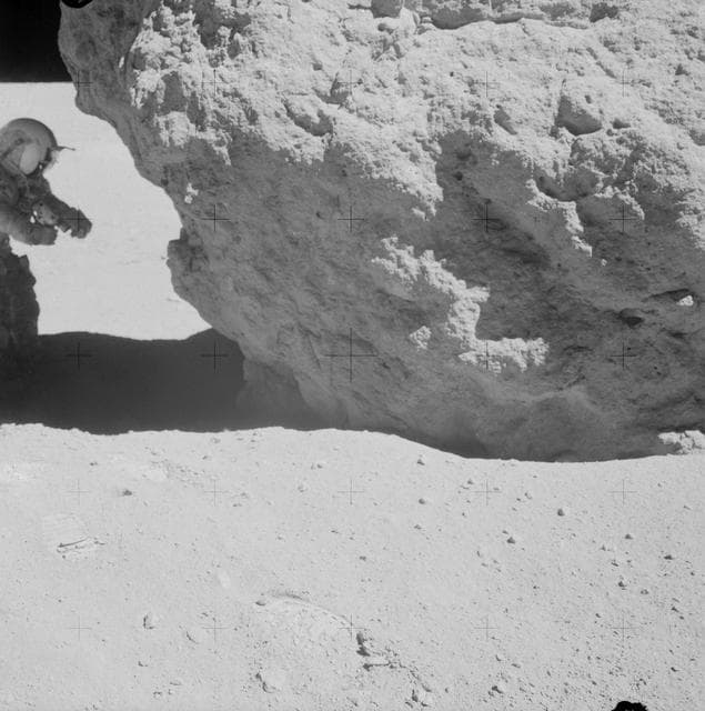 Astronaut John Young looks over a boulder at Station no. 13 during EVA