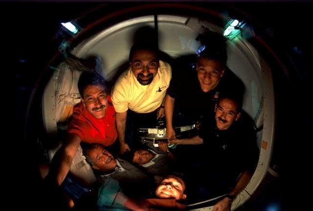 NASA image: STS-100 crew in docking compartment after docking with ISS