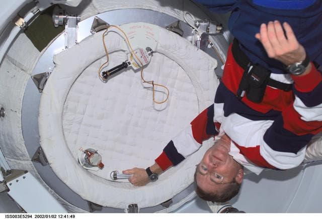 NASA image: Frank Culbertson closes the PMA2 hatch after the Expedition Two crew egress