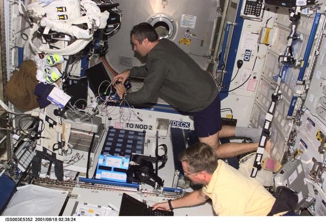 NASA image: Dezhurov and Culbertson work on laptops in the U.S. Laboratory during Expedition Three