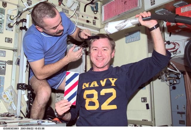 NASA image: Tyurin gives Culbertson a haircut in the Service Module during Expedition Three