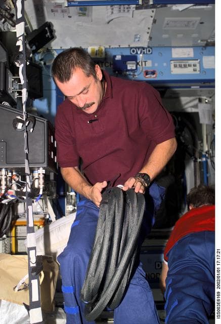 NASA image: Tyurin works with a hose in the U.S. Laboratory during Expedition Three