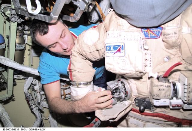 NASA image: Dezhurov works on an Orlan suit in Pirs during Expedition Three