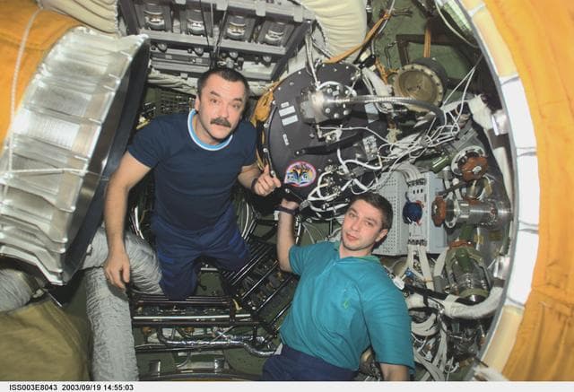 NASA image: Tyurin and Koveez handle the Plasmakristall Telescience Apparatus during Expedition Three