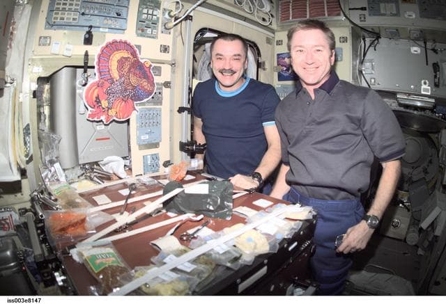 NASA image: Tyurin and Culbertson eat a Thanksgiving meal in Zvezda during Expedition Three