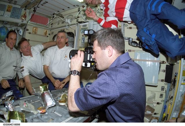 NASA image: STS-110 crewmembers pose for photos in the Zvezda SM during Expedition Four