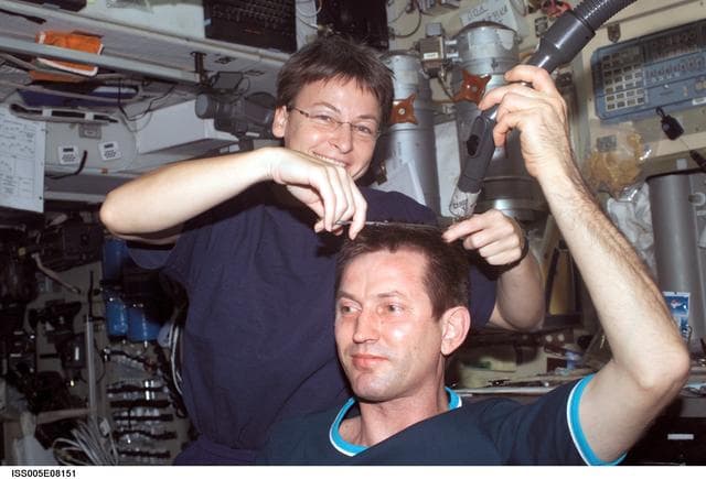 NASA image: Whitson cuts Treschev's hair in the SM during Expedition Five on the ISS