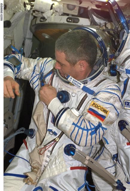 NASA image: Korzun makes an adjustment to his Russian Sokol suit during Expedition Five on the ISS