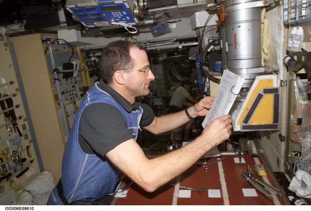 NASA image: Expedition Six Flight Engineer Pettit is looking at a procedures checklist