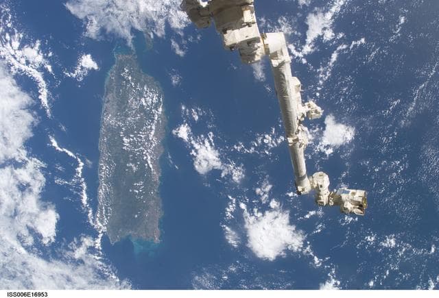 NASA image: View of the extended SSRMS or Canadarm2 with cloudy view in the background