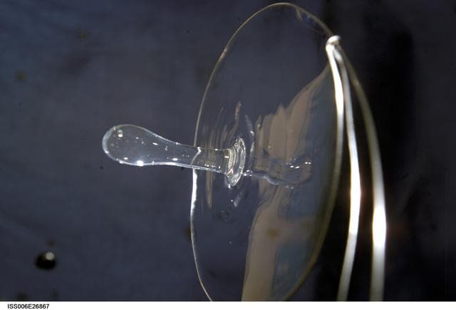 NASA image: View of a surface tension demonstration using water that is being held in place by a 50mm metal loop