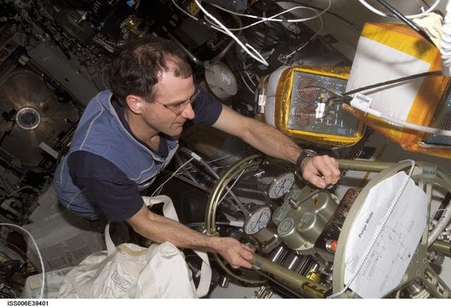 NASA image: Flight Engineer Donald R. Pettit making a valve adjustment to the FCPA