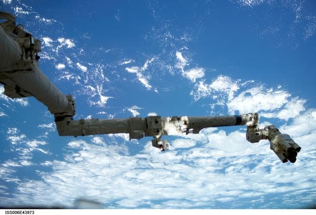 NASA image: View of the SSRMS/Canadarm2 with blue and white Earth in the background during Expedition Six