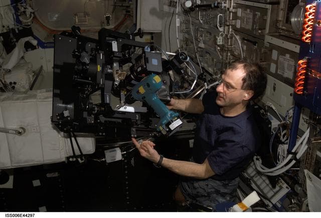 NASA image: Pettit looks through a spotting scope and runs a drill at the same time in the U.S. Laboratory