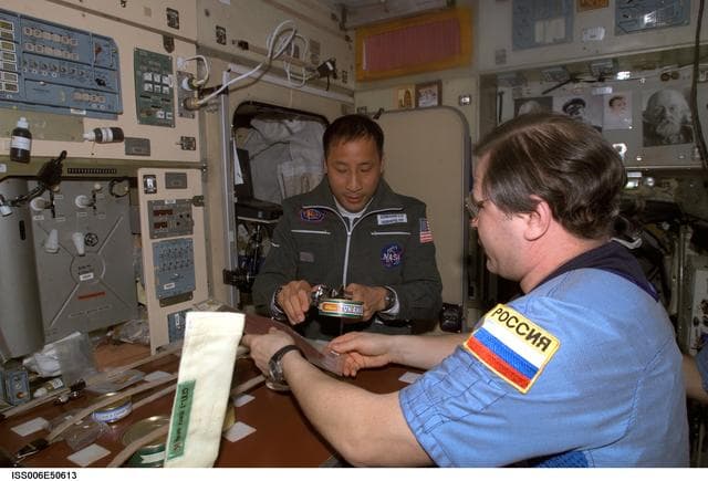 NASA image: Nikolai Budarin and Edward Lu share a meal in the SM