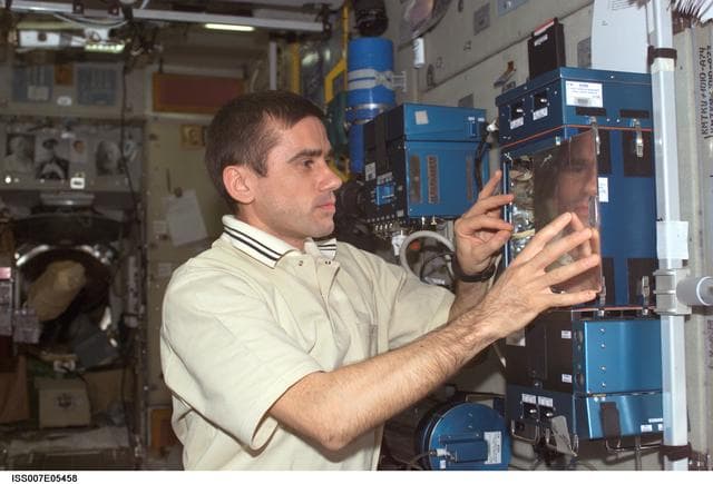 NASA image: CDR Malenchenko removes pea pods from Lada greenhouse