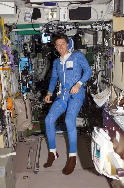 NASA image: Foale, in SM, suited in blue thermal garment prior to EVA during Expedition 8
