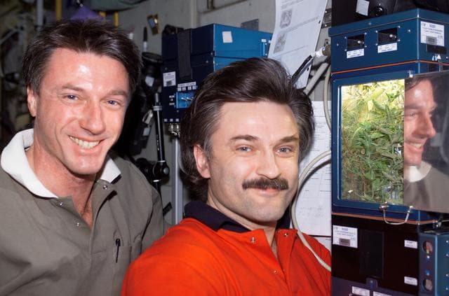 NASA image: Foale and Kaleri pose beside the LADA-4 greenhouse in the U.S. Lab during Expedition 8