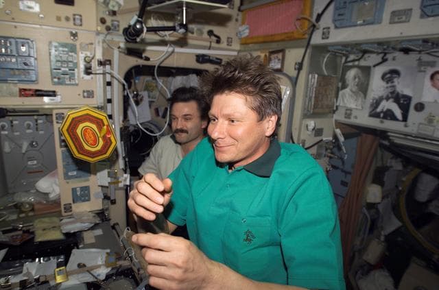 NASA image: Padalka spins a box of chocolates as Kaleri looks on in the SM during EXP 9 / EXP 8