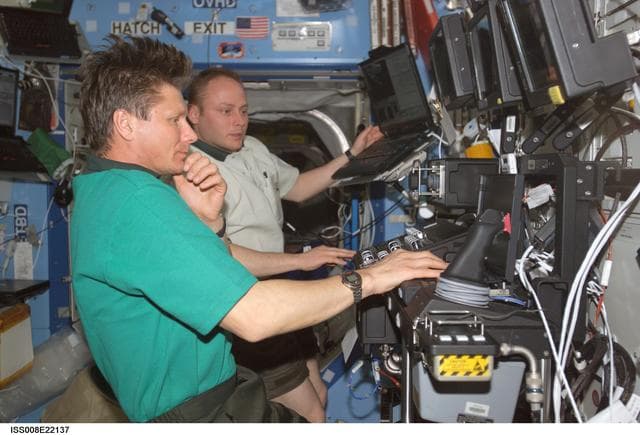 NASA image: Padalka and Fincke work at the SSRMS controls in the U.S. Lab during EXP 8 / EXP 9