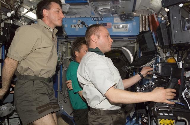 NASA image: Foale observes Fincke as he works the SSRMS controls in the U.S. Lab during EXP 8 / EXP 9