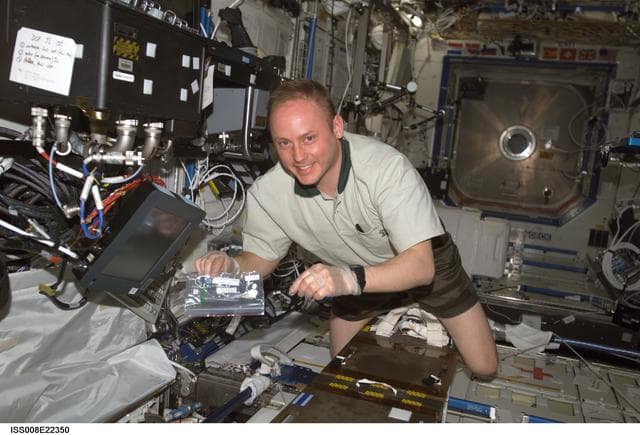 NASA image: Fincke holds an ammonia test strip while working in the U.S. Laboratory during EXP 9 / EXP 8