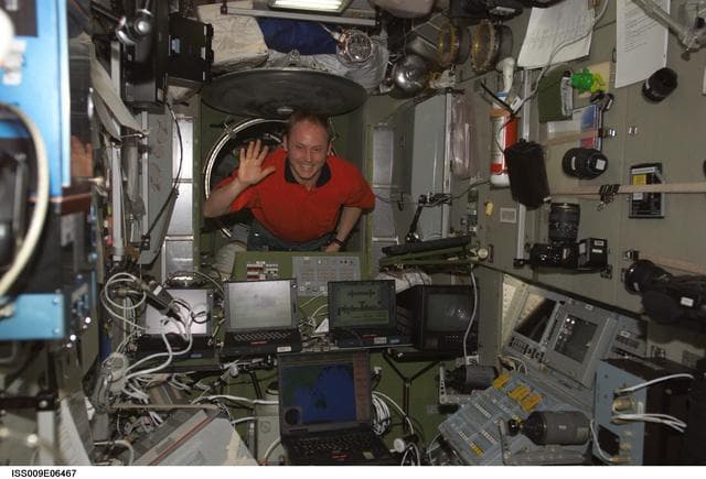 NASA image: Fincke waves as he enters the Zvezda Service Module during Expedition 9
