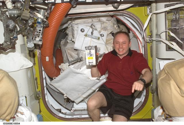 NASA image: Fincke holds up a spare RPCM in the A/L during Expedition 9