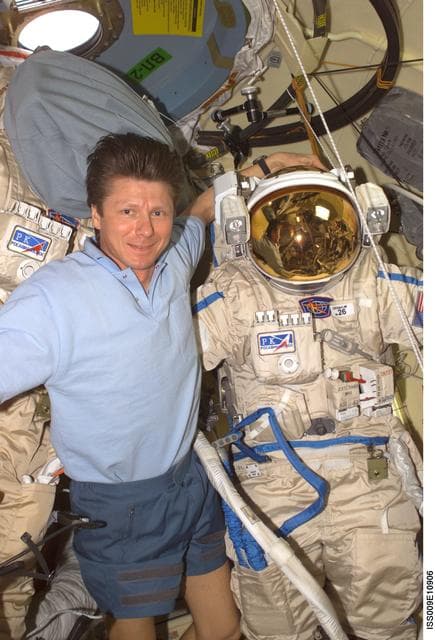 NASA image: Padalka poses with an Orlan EVA suit during checkout operations on Expedition 9