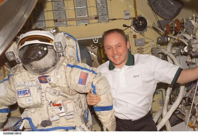 NASA image: Fincke posses with an Orlan EVA suit inside the Pirs DC during Expedition 9