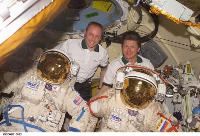 NASA image: Fincke and Padalka pose with their Orlan EVA suits inside the Pirs DC during Expedition 9