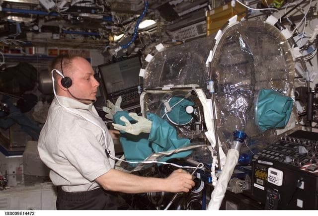 NASA image: Fincke conducts ISSI tests inside the MWA containment system onboard the U.S. Lab during Expedition 9