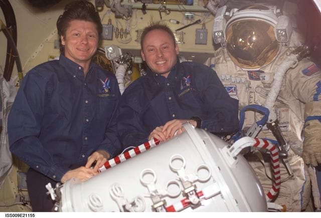 NASA image: Padalka and Fincke pose with Orlan suit in the Pirs Docking Compartment during Expedition 9