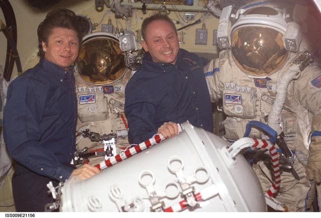 NASA image: Padalka and Fincke pose with Orlan suit in the Pirs Docking Compartment during Expedition 9