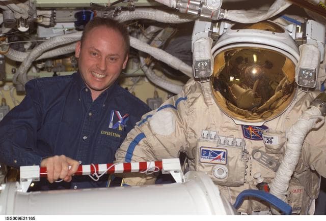 NASA image: Padalka and Fincke pose with Orlan suit in the Pirs Docking Compartment during Expedition 9