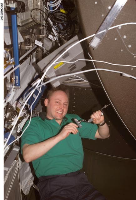 NASA image: Fincke unbolts the front panel of the CHeCS Rack for inspection and cleaning during Expedition 9