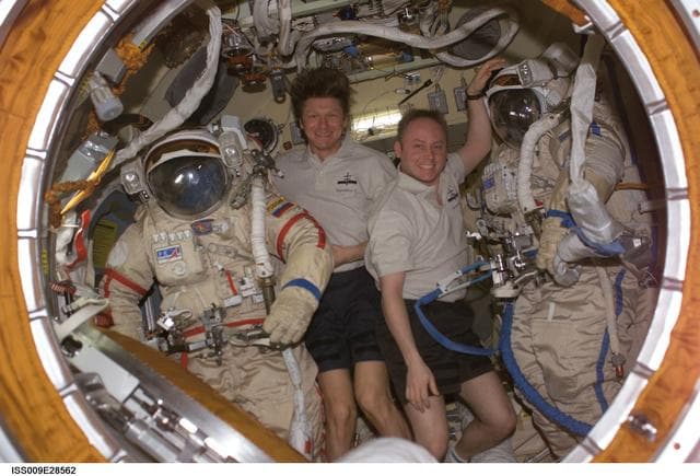 NASA image: Padlaka and Fincke pose with Orlan suits inside the Pirs DC during Expedition 9