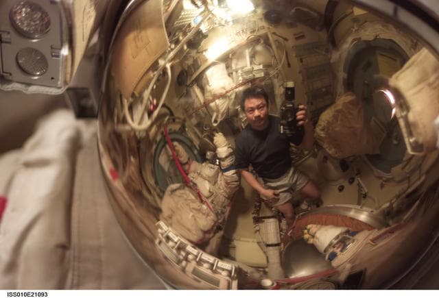 NASA image: Chiao appears as a small reflection in a helmet visor in the Pirs DC1