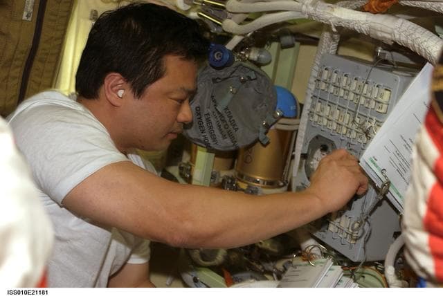NASA image: Chiao makes adjustment on the Russian Orlan Interface Unit in the Pirs DC1 during Expedition 10