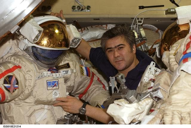 NASA image: Sharipov poses with Russian Orlan suits in the Pirs DC1 during Expedition 10