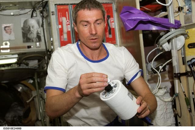 NASA image: Krikalev holds tube within CPCF-2 Activation Mechanism during Expedition 10 / Expedition 11