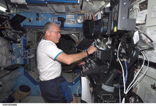NASA image: Phillips at the SSRMS controls in the U.S. Laboratory during Expedition 10 / Expedition 11