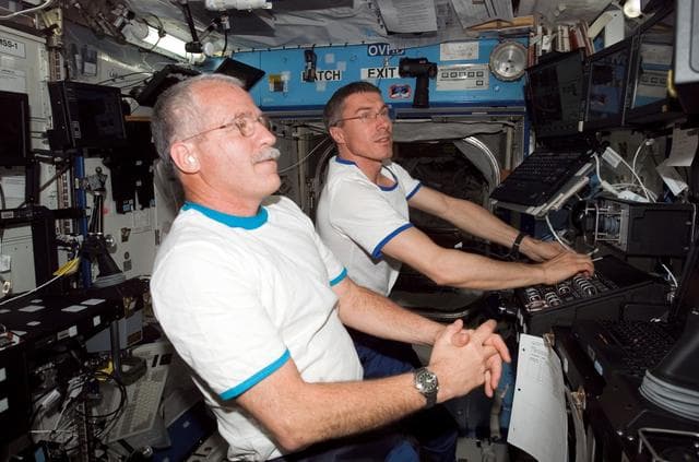 NASA image: Krikalev and Phillips at the SSRMS controls in the U.S. Laboratory during Expedition 10 / Expedition 11