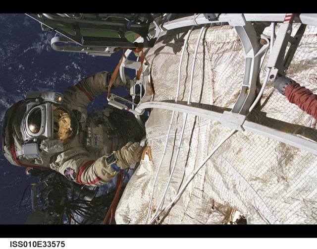 NASA image: Sharipov works on communication equipment in EVA during Expedition 10