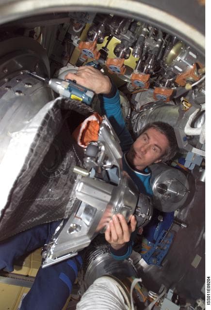 NASA image: Krikalev dismantles probe-and-cone docking mechanism (StM) in the Progress M-53 (18P)